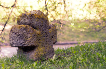 Cross in the graveyard near green grass