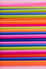 colored tubules for juice and cocktails on pink background. Colorful drink straws. straw, plastic free, reusable plastic drinking background, plastic free. Plastic pollution concept.
