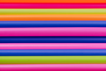 colored tubules for juice and cocktails on pink background. Colorful drink straws. straw, plastic free, reusable plastic drinking background, plastic free. Plastic pollution concept.