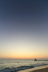 Fototapeta premium The beautiful light of the sunset at the sea. Mae Ramphueng Beach, Taphong Subdistrict, Mueang Rayong District, Rayong Province, Thailand
