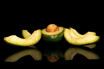 Group of one half four slices of fresh green avocado isolated on black glass