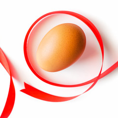 Healthy food concept, Isolated fresh chicken  egg with red ribbon decorated on white table background-top view-selective egg soft focus