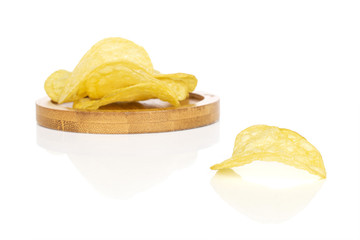Lot of whole crisp potato chip on round bamboo coaster isolated on white background