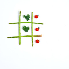 tic tac toe with food, asparagus kale, tomato, top view