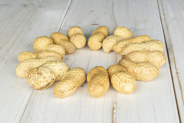 Lot of whole tasty beige peanut circle on white wood