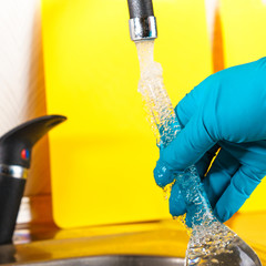 water purification specialist tap water pours into a glass flask.