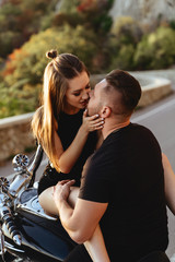 Portrait of beautiful young couple on a motorcycle. Attractive young woman with handsome young man on motorbike.