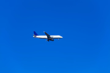 Comercial airplane flying in a beautiful blue sky day