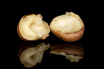 Group of two halves of tasty brown hazelnut isolated on black glass