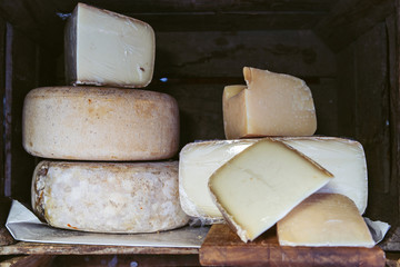Cantal or saint nectaire french mature cheese on the wooden shelf stored for sale or use organic food