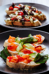 Italian Appetizer Bruschetta with roasted tomatoes, mozzarella cheese, garlic and herbs on wooden table