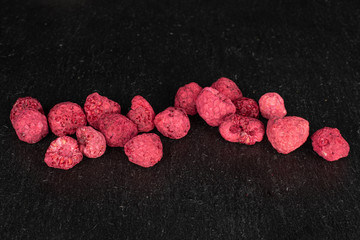 Lot of whole dried raspberry on grey stone