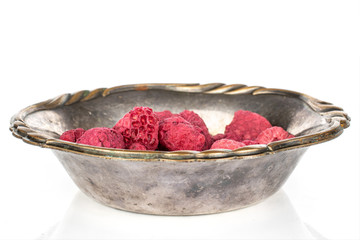 Lot of whole dried raspberry in copper bowl isolated on white background
