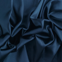 Wavy blue silk, atlas or veil fabric, crumpled with creases, bended in spiral wrinkle