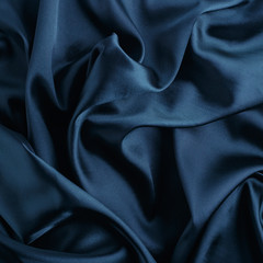 Wavy blue silk, atlas or veil fabric, crumpled with creases, bended in spiral wrinkle