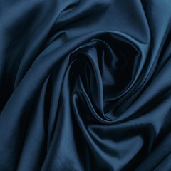 Wavy blue silk, atlas or veil fabric, crumpled with creases, bended in spiral wrinkle