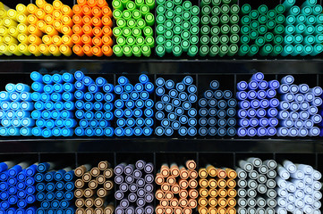 A lot of markers are on the shelf in the store. Color spectrum of markers.