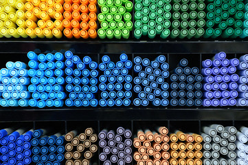 A lot of markers are on the shelf in the store. Color spectrum of markers.