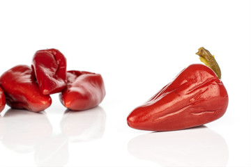 Group of four whole pickled red pepper isolated on white background