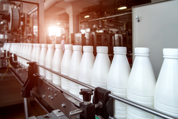 White plastic milk bottles on the conveyor on a modern dairy plant