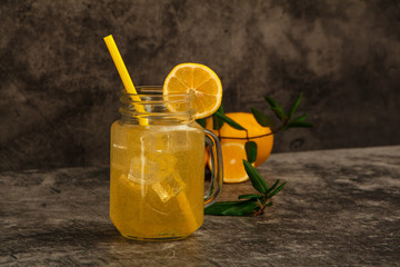 Fresh lemon juice with ice with fresh lemons on a gray background. Lemonade with fresh lemons on a gray background. Fresh juice lemonade.