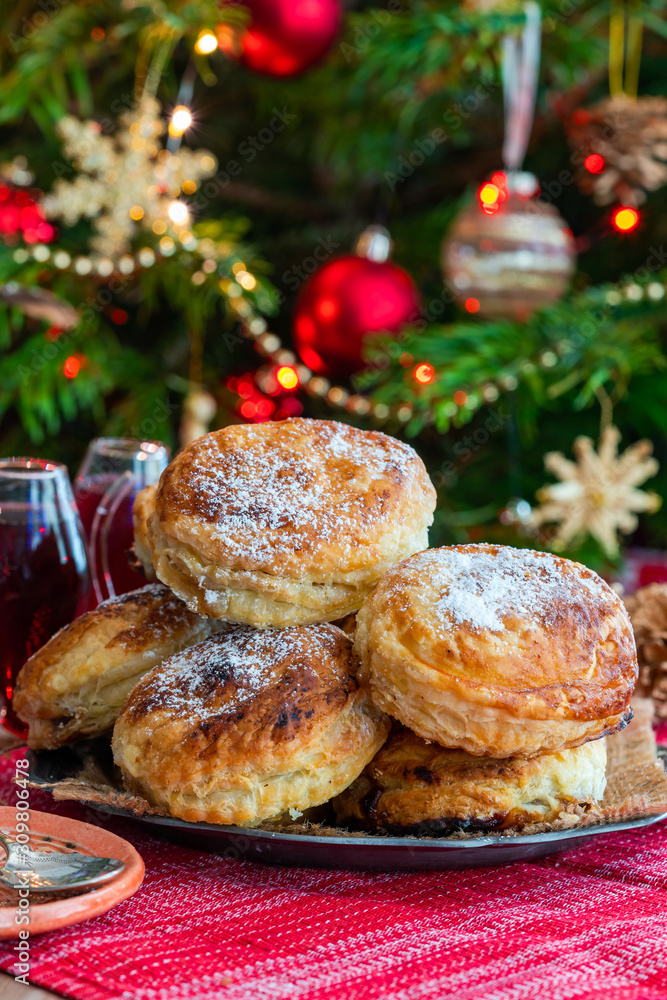 Wall mural homemade christmas puff pastry mince pies with christmas tree in the background