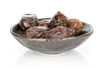 Lot of whole dried brown date fruit in glazed bowl isolated on white background