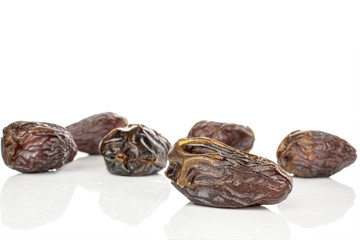 Group of six whole dried brown date fruit isolated on white background