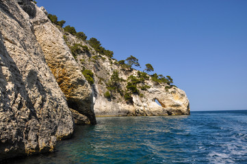 Fototapeta na wymiar Mediterranean sea coast landscape, blue clear sky and sea, with an opening in the rock.
