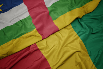 waving colorful flag of guinea and national flag of central african republic.