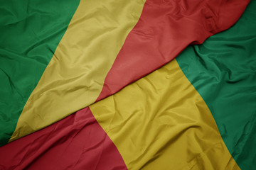 waving colorful flag of guinea and national flag of republic of the congo.
