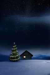 Weihnachtlich beleuchtete Hütte in Kalter Winternacht mit Sternenhimmel und Christbaum