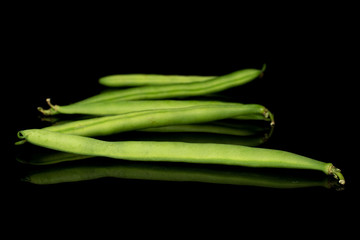 Group of five whole snap green bean isolated on black glass