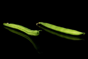 Group of two whole snap green bean isolated on black glass