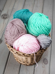 Fototapeta na wymiar Balls of yarn for knitting. Balls of yarn for knitting in a wicker basket. Knitting thread. Colorful threads.