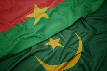 waving colorful flag of mauritania and national flag of burkina faso.