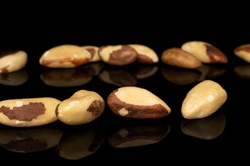 Lot of whole brazil brown nut in row isolated on black glass
