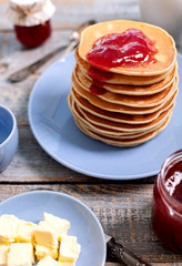 Tasty breakfast. Pancakes with strawberry confiture and butter.