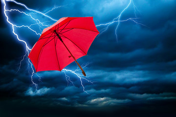 roter Regenschirm fliegt beim Unwetter davon