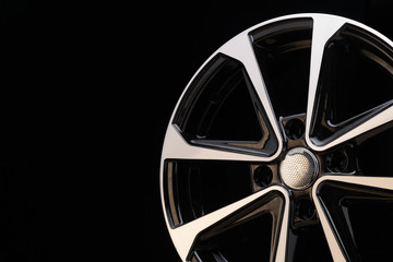 cast aluminum disc alloy wheel modern, close-up on black background, spokes and rim copy space