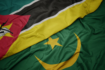 waving colorful flag of mauritania and national flag of mozambique.