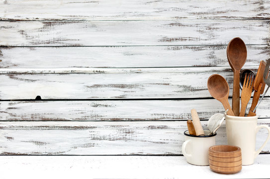 Vintage old baking utensils on a white wooden background.