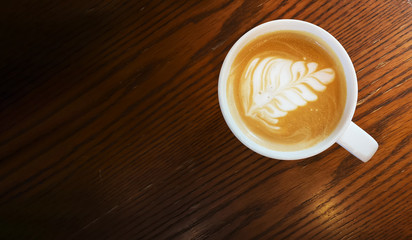  top view of Hot art Latte Coffee in a cup on wooden table.