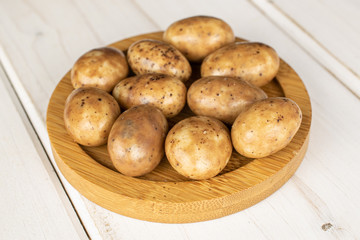 Lot of whole tiramisu brown almond nut on round bamboo coaster on white wood