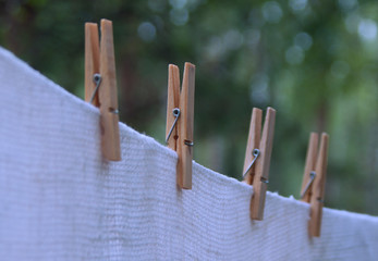 fresh white linen hanging on a rope with wooden clothespins