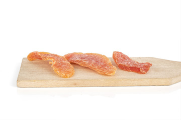 Group of three whole dried orange papaya piece on wooden cutting board isolated on white background