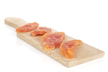 Group of four whole dried orange papaya piece on wooden cutting board isolated on white background