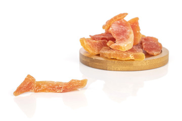 Lot of whole dried orange papaya piece on round bamboo coaster isolated on white background