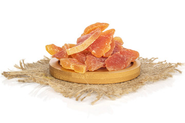 Lot of whole dried orange papaya piece with jute fabric on round bamboo coaster isolated on white background