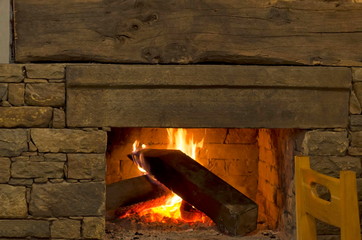 Fire in a fireplace with logs and flames, creating a feeling of warmth and comfort, Oreshak village, Troyan, Bulgaria 